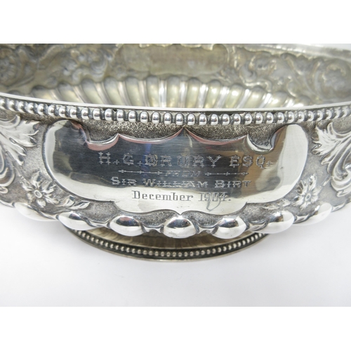 51 - An impressive large Victorian silver oval Bowl with floral and scroll embossing, mask handles, inscr... 