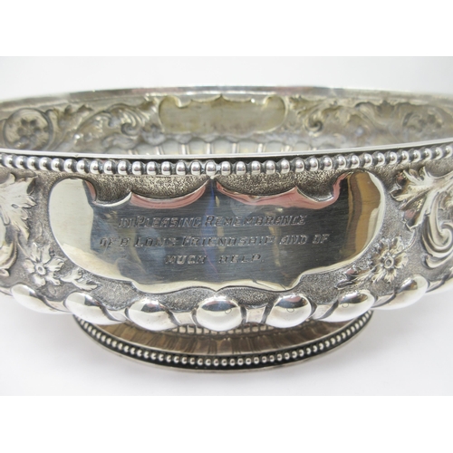 51 - An impressive large Victorian silver oval Bowl with floral and scroll embossing, mask handles, inscr... 