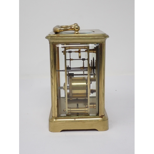 513 - A brass cased Carriage Clock, the enamel dish marked with Roman numerals, name indistinct, 5¼in H