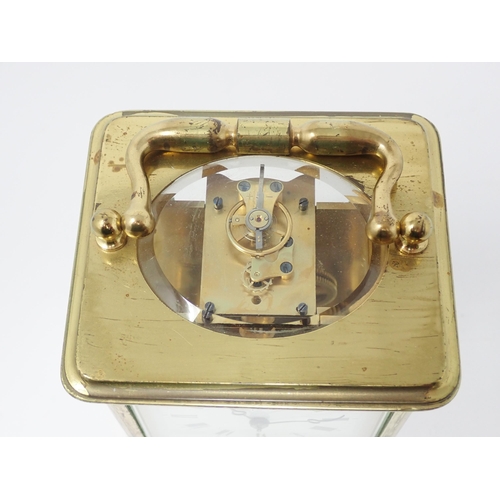 513 - A brass cased Carriage Clock, the enamel dish marked with Roman numerals, name indistinct, 5¼in H