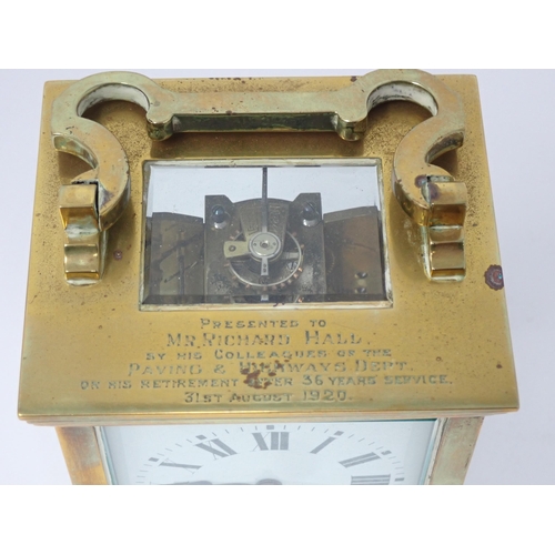 514 - A brass cased Carriage Clock, with presentation inscription to the top, the white enamel dial inscri... 