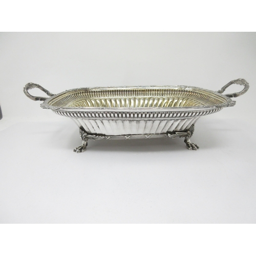 52 - A silver two-handled Fruit Basket with gadrooning and leafage engraving, gilt interior on paw feet, ... 