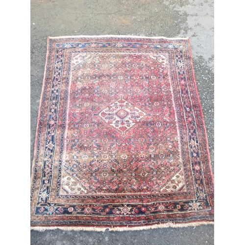 525 - A bordered Hamadan type Rug with central stepped medallion surrounded by stylised flowers on a red g... 