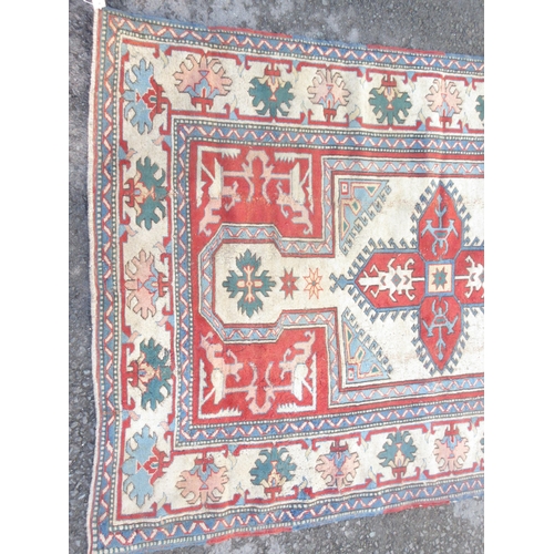 527 - A bordered Kazak type Rug with central star medallion with latch hooks on a camel, red and blue grou... 