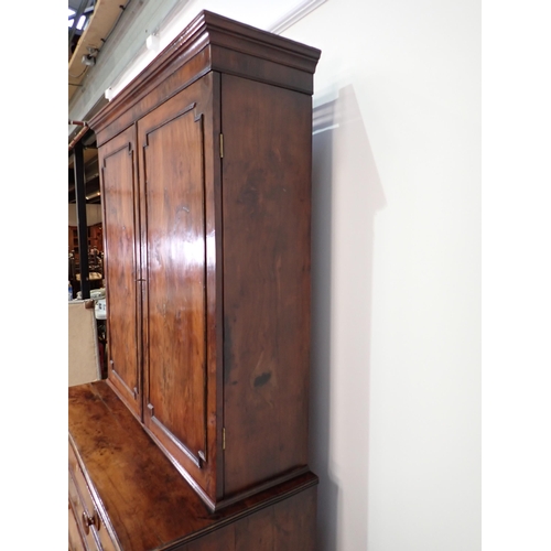 546 - An early 19th Century yew wood Secretaire Bookcase, the upper section with raised moulded panelled d... 