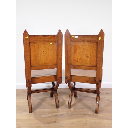 555 - A pair of Arts and Crafts Hall Chairs with arched back supports, carved incised stylised floral desi... 