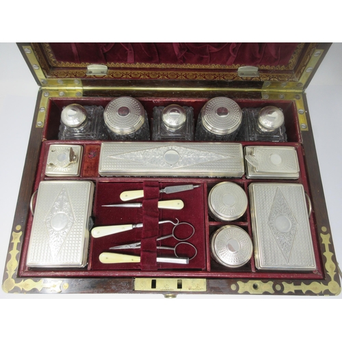 6 - An early Victorian rosewood Dressing Case with brass inlay, the interior with numerous silver lidded... 