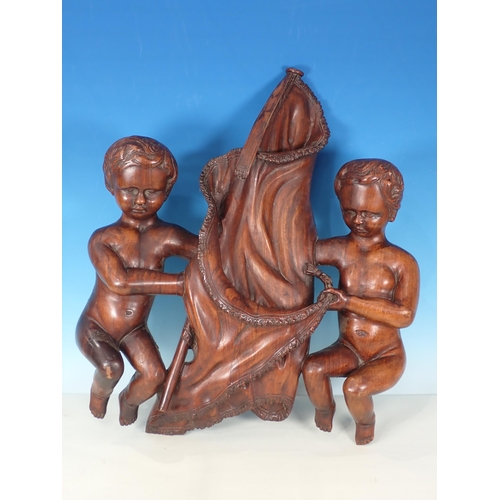 606 - A 19th Century Continental walnut carving of putti cherubs holding a flag, 2ft H