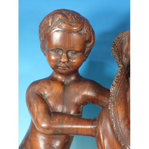 606 - A 19th Century Continental walnut carving of putti cherubs holding a flag, 2ft H