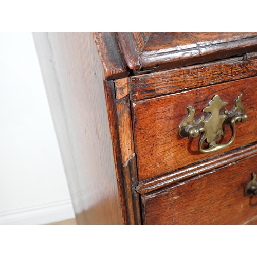 607 - A George III oak Bureau with fielded fall front enclosing pigeon holes and drawers above two short a... 