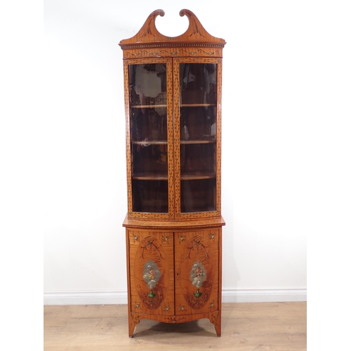 625 - A satinwood bow fronted glazed Cabinet with arched pediment, the upper section fitted adjustable she... 