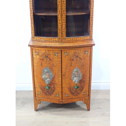 625 - A satinwood bow fronted glazed Cabinet with arched pediment, the upper section fitted adjustable she... 