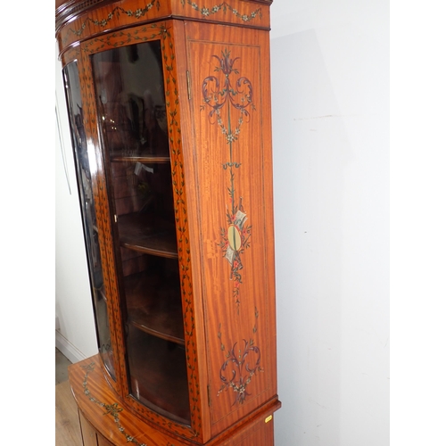 625 - A satinwood bow fronted glazed Cabinet with arched pediment, the upper section fitted adjustable she... 