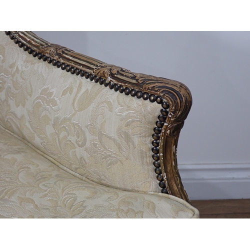 626 - A 19th Century gilt framed winged Armchair on carved cabriole leg supports, upholstered in cream dam... 