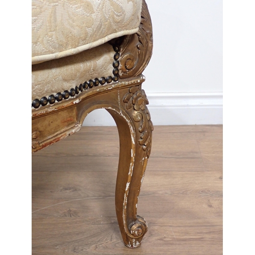 626 - A 19th Century gilt framed winged Armchair on carved cabriole leg supports, upholstered in cream dam... 