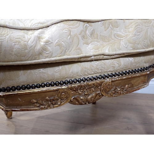 626 - A 19th Century gilt framed winged Armchair on carved cabriole leg supports, upholstered in cream dam... 