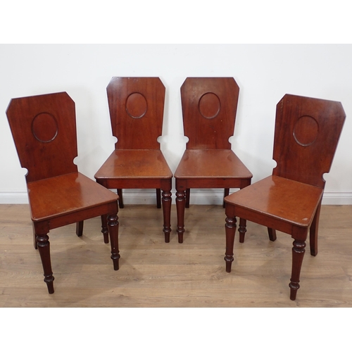 628 - A mid 19th Century Set of four mahogany Hall Chairs, the shaped rectangular backs with oval panels a... 