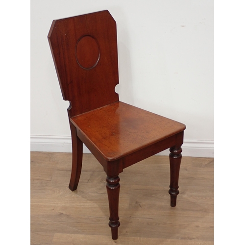 628 - A mid 19th Century Set of four mahogany Hall Chairs, the shaped rectangular backs with oval panels a... 