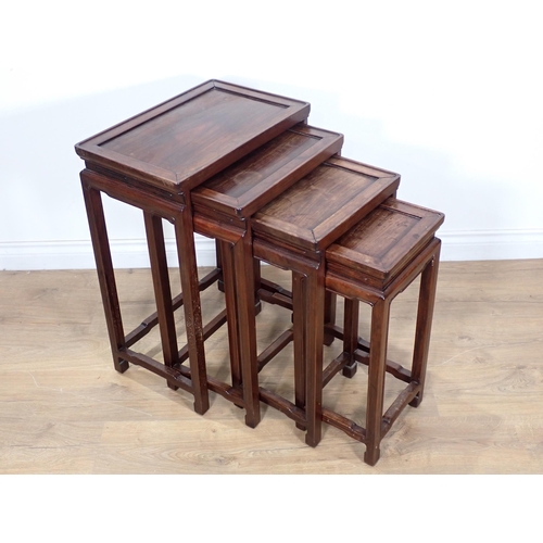 633 - A Nest of four Chinese hardwood Coffee Tables with recessed tops, shaped side rails and fluted legs ... 