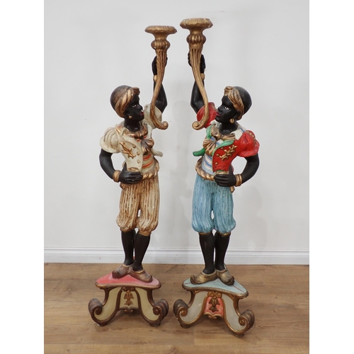 638 - A pair of decorated Blackamoor Figures, each with an outstretched arm holding a stylised cornucopia,... 