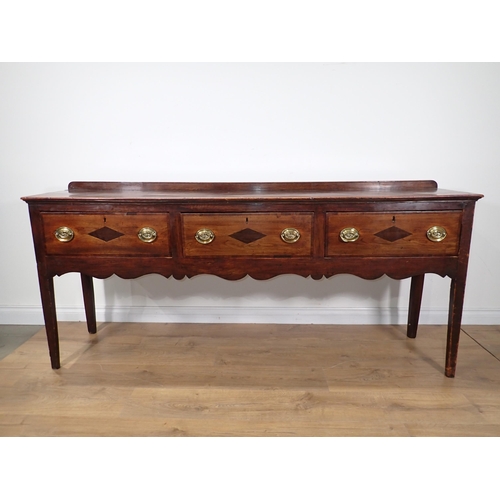 650 - An 18th Century fruitwood Dresser Base fitted with three mahogany crossbanded drawers above Cupid's ... 