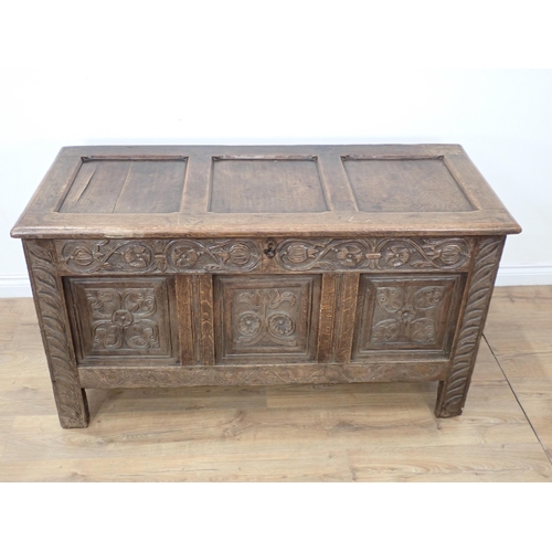 659 - A 17th Century oak Coffer with hinged panelled top carved frieze above three carved panels, 4ft 7½ i... 