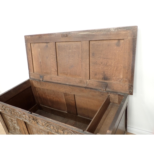 659 - A 17th Century oak Coffer with hinged panelled top carved frieze above three carved panels, 4ft 7½ i... 