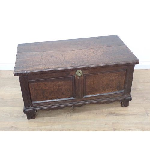 664 - A small 17th Century carved oak Coffer with moulded hinged top, panelled front above a shaped frieze... 