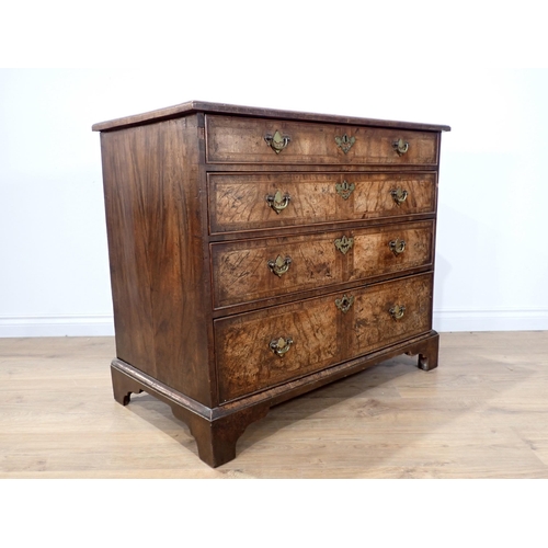 665 - A Queen Anne walnut Chest with quarter veneered feather and crossbanded top above four long graduate... 