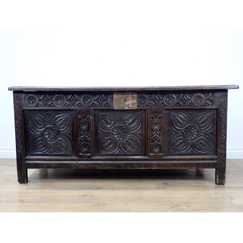 684 - A 17th Century oak Coffer with sunken three panel lid above scroll carved frieze and three floral ca... 