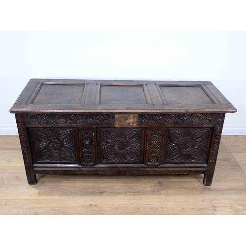 684 - A 17th Century oak Coffer with sunken three panel lid above scroll carved frieze and three floral ca... 