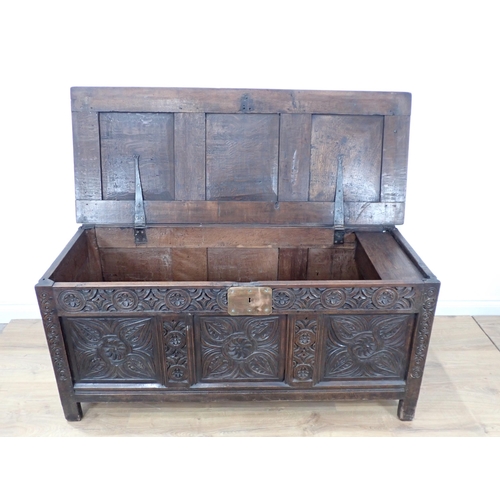 684 - A 17th Century oak Coffer with sunken three panel lid above scroll carved frieze and three floral ca... 