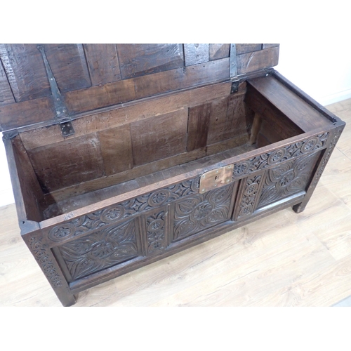 684 - A 17th Century oak Coffer with sunken three panel lid above scroll carved frieze and three floral ca... 