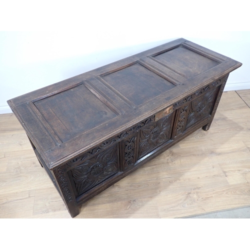 684 - A 17th Century oak Coffer with sunken three panel lid above scroll carved frieze and three floral ca... 