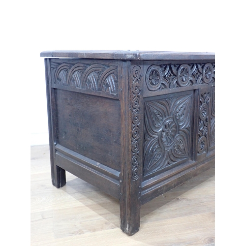 684 - A 17th Century oak Coffer with sunken three panel lid above scroll carved frieze and three floral ca... 