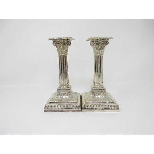 78 - A pair of Victorian silver Candlesticks with fluted columns having corinthian capitals on beaded squ... 