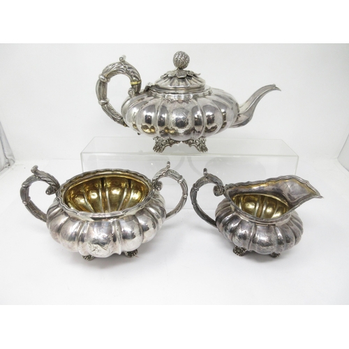 93 - A George IV silver three piece Tea Service of melon shape, engraved shield crest and motto, London 1... 