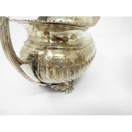 95 - An Edward VII silver Milk Jug of boat shape with gadroon body on anthemion and paw feet, London 1908... 