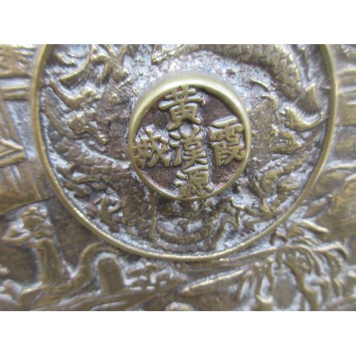 426 - An Oriental bronze Plaque depicting numerous figures in a landscape, 11 1/2in diam, raised on a carv... 