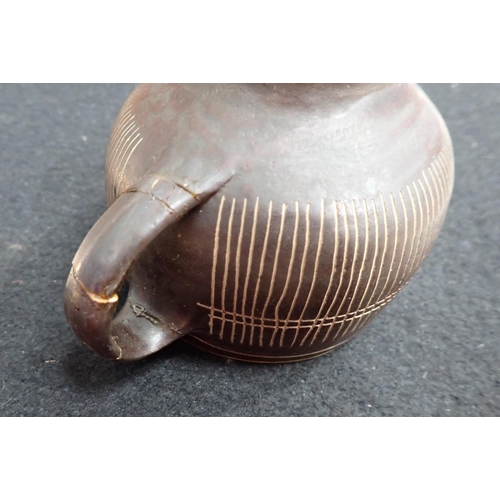 375 - Two Lucie Rie Cups and Saucer in a brown glaze with cream trellis designs, loop handles to the bulbo... 