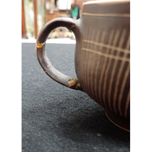 375 - Two Lucie Rie Cups and Saucer in a brown glaze with cream trellis designs, loop handles to the bulbo... 