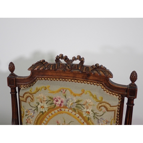 32 - A pair of French walnut Elbow Chairs with finely carved ribbon surmounts and pineapple finials, flut... 