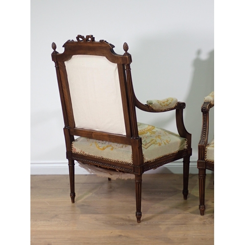 32 - A pair of French walnut Elbow Chairs with finely carved ribbon surmounts and pineapple finials, flut... 