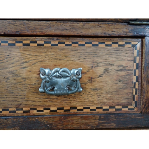 354 - An Arts and Crafts Desk with sloping front and two drawers with chequered inlay on squared supports,... 