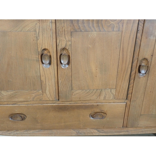 60 - An Ercol elm Sideboard fitted three cupboard doors and drawer 3ft 9in W x 2ft 8in H