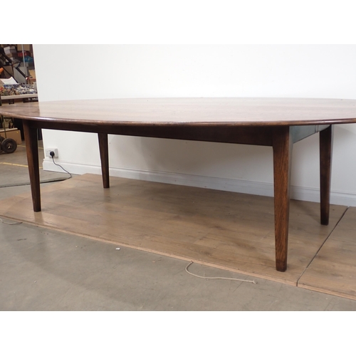 647 - A large oval oak Dining Table on square cut supports made by I. & J.L. Brown 9ft L x 5ft W x 2ft 5in... 