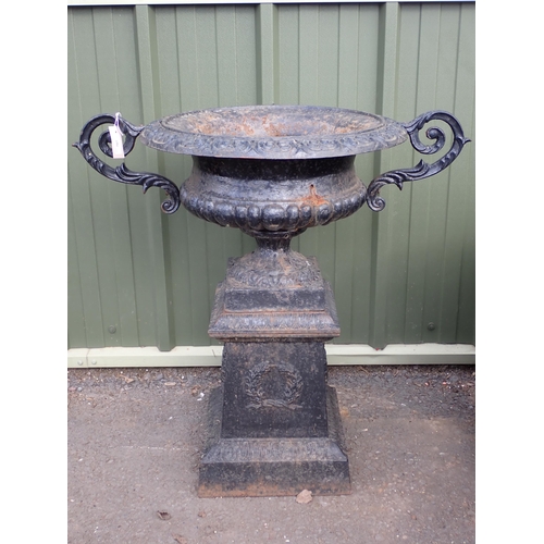 707 - A reproduction black painted cast iron two handled Urn on pedestal base decorated laurel wreaths, 2f... 