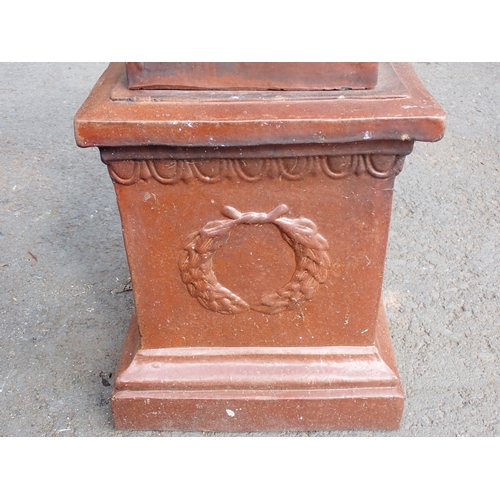 709 - A terracotta salt glazed Urn on pedestal with laurel wreath decoration 2ft 4in H