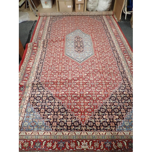 734 - A modern red ground Carpet with blue central medallion amongst floral design within multiple borders... 