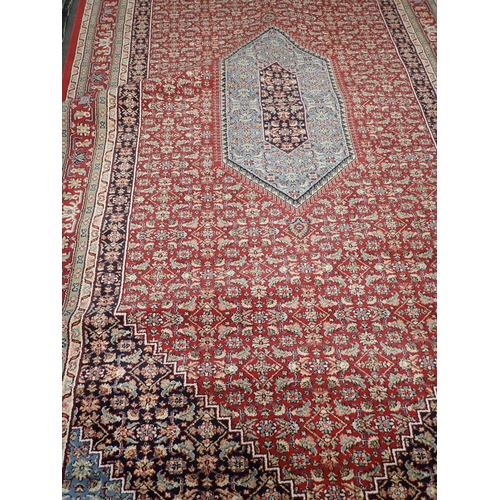 734 - A modern red ground Carpet with blue central medallion amongst floral design within multiple borders... 